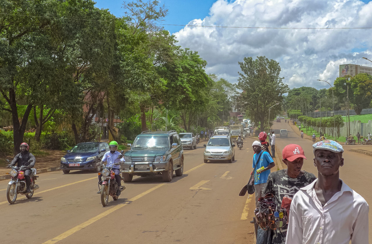 REAR VIEW OF PEOPLE ON ROAD AGAINST SKY