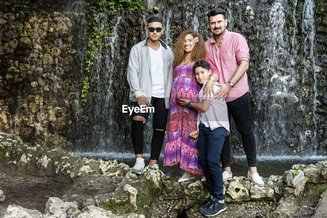 Full length of family standing against waterfall