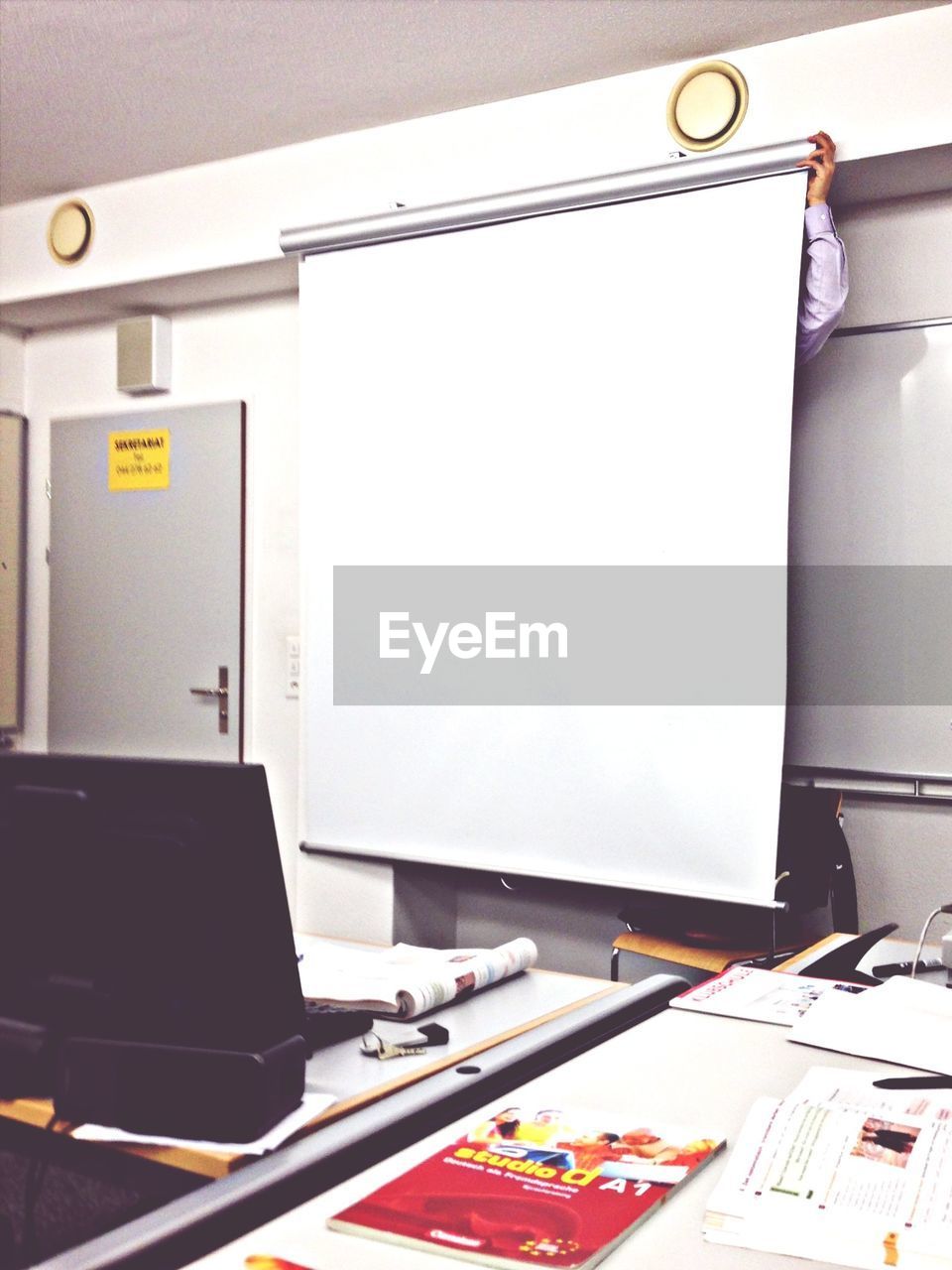 Man hiding behind projector screen