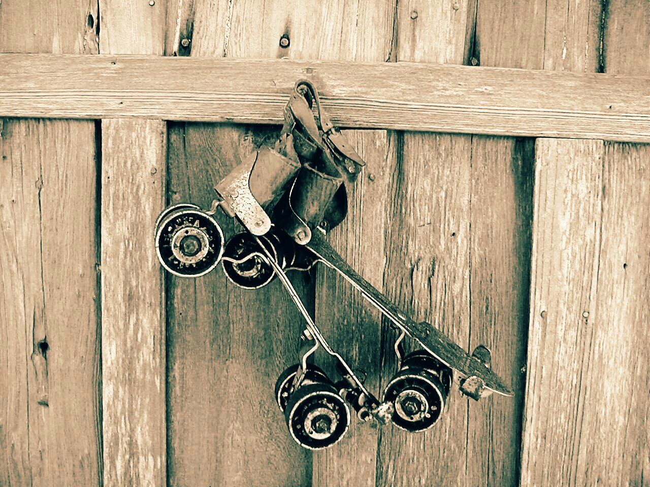 Close-up of roller skates hanging on wooden wall