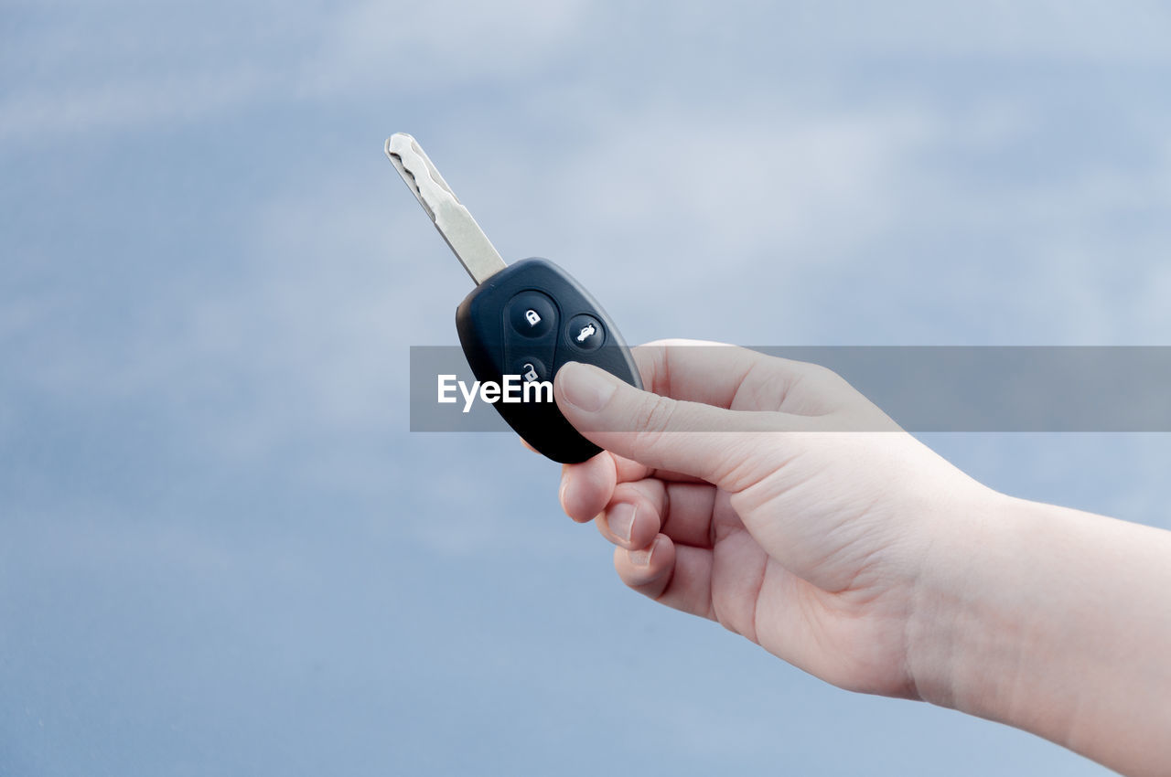 Close-up of person holding car key 