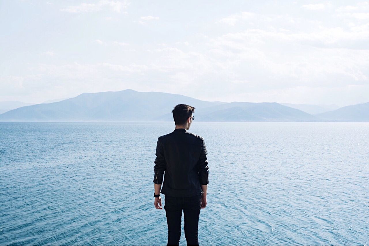 Young man standing in front of sea
