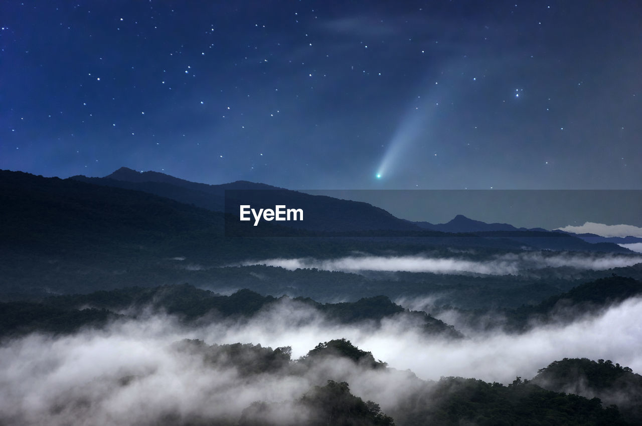 The sea of mist at night in the forest in the sky with meteors.