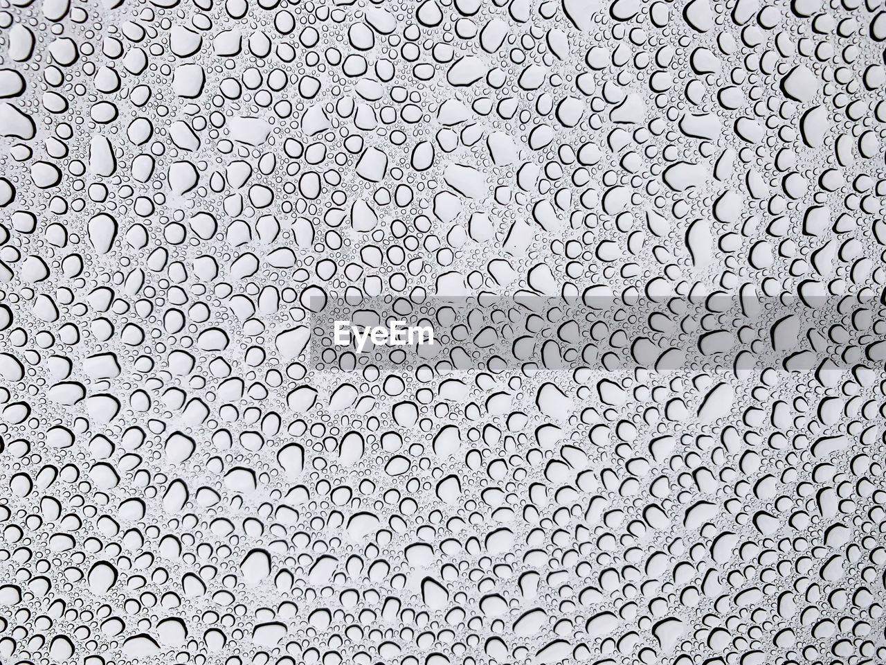 FULL FRAME SHOT OF RAINDROPS ON GLASS