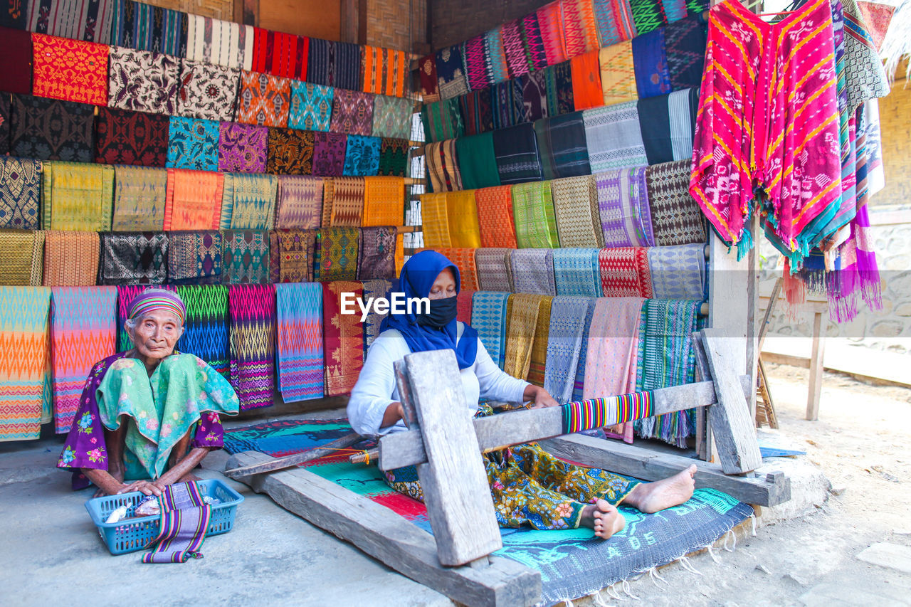 FULL LENGTH OF PEOPLE WORKING IN COLORFUL TRADITIONAL CLOTHING