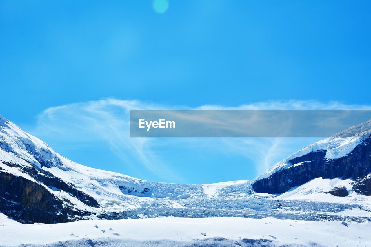 Scenic view of snow covered mountains against sky