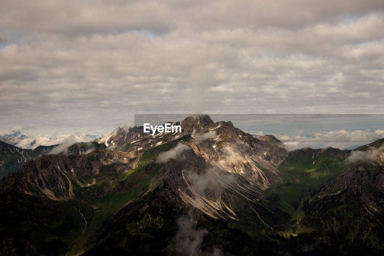 Scenic view of mountains against cloudy sky