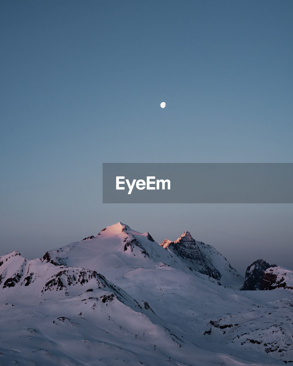 Scenic view of snowcapped mountain against clear sky during winter