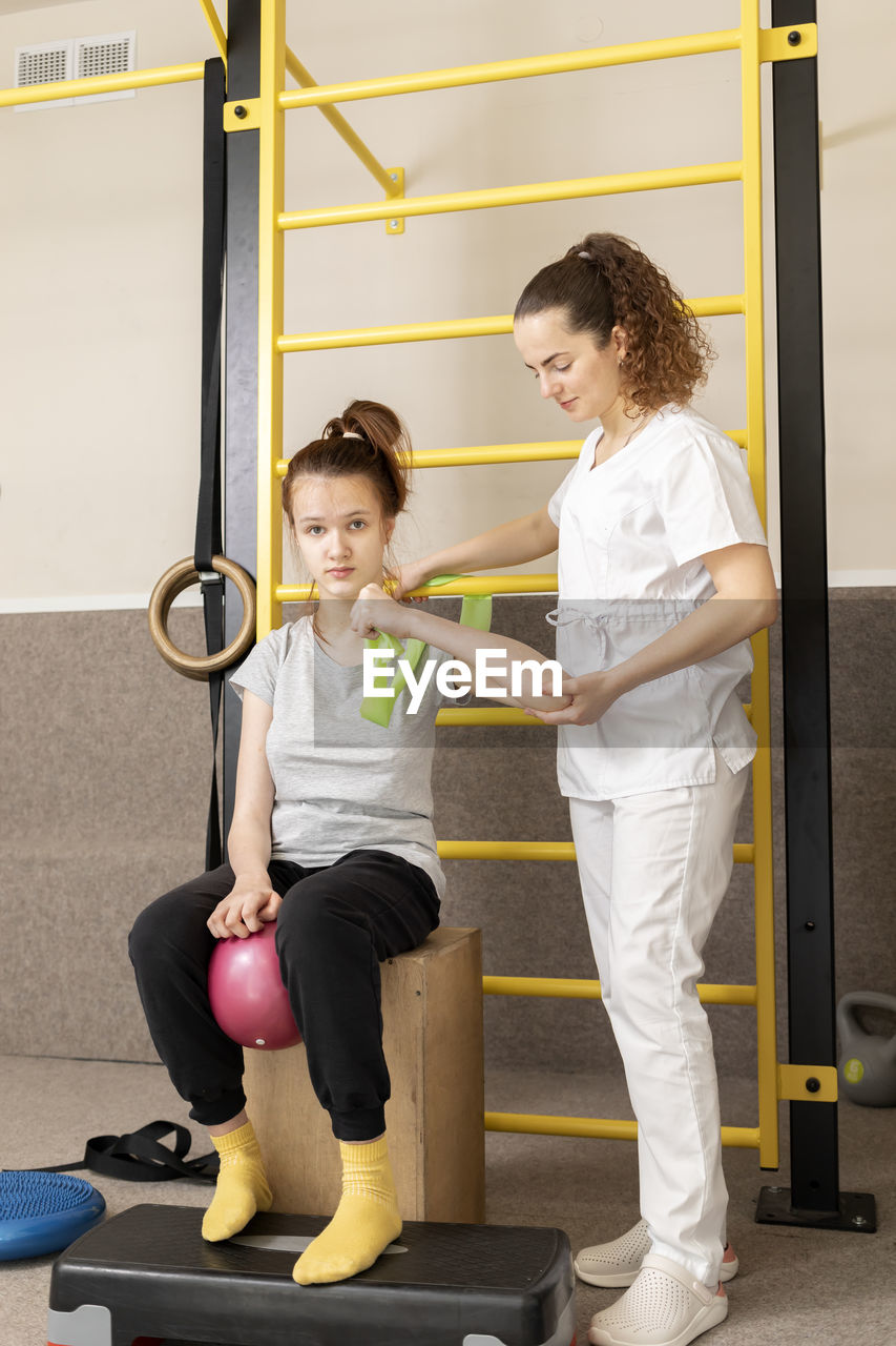 Disabled child with doctor does physical exercises in rehabilitation room. kid with special needs