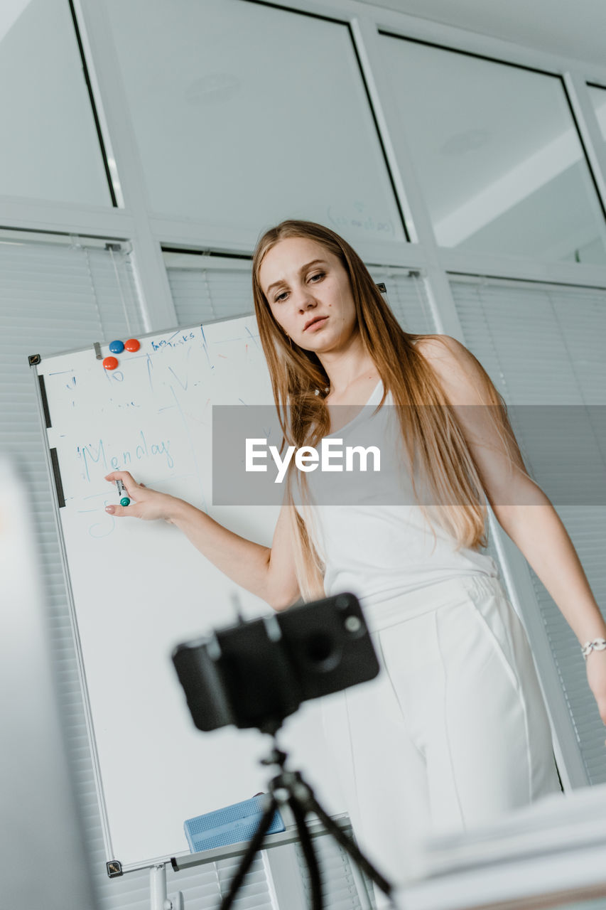 Young woman teaching students over video call