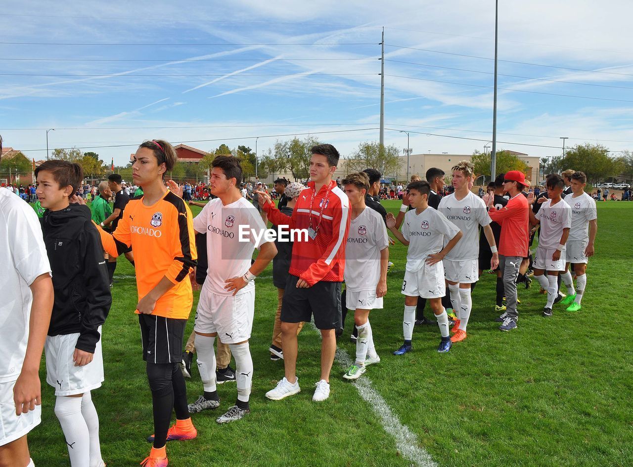 PANORAMIC SHOT OF PEOPLE STANDING ON FIELD