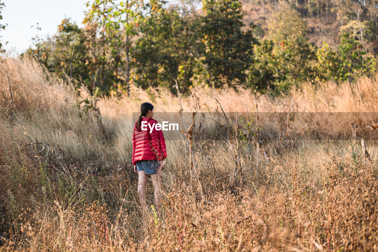 Rear view of woman walking on field