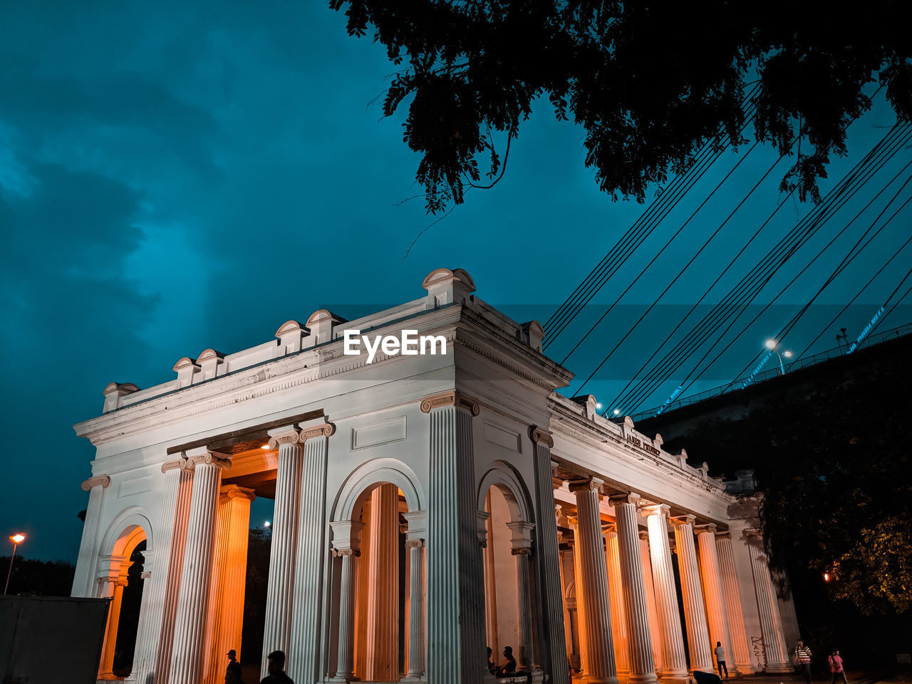 LOW ANGLE VIEW OF ILLUMINATED BUILDING AGAINST BLUE SKY