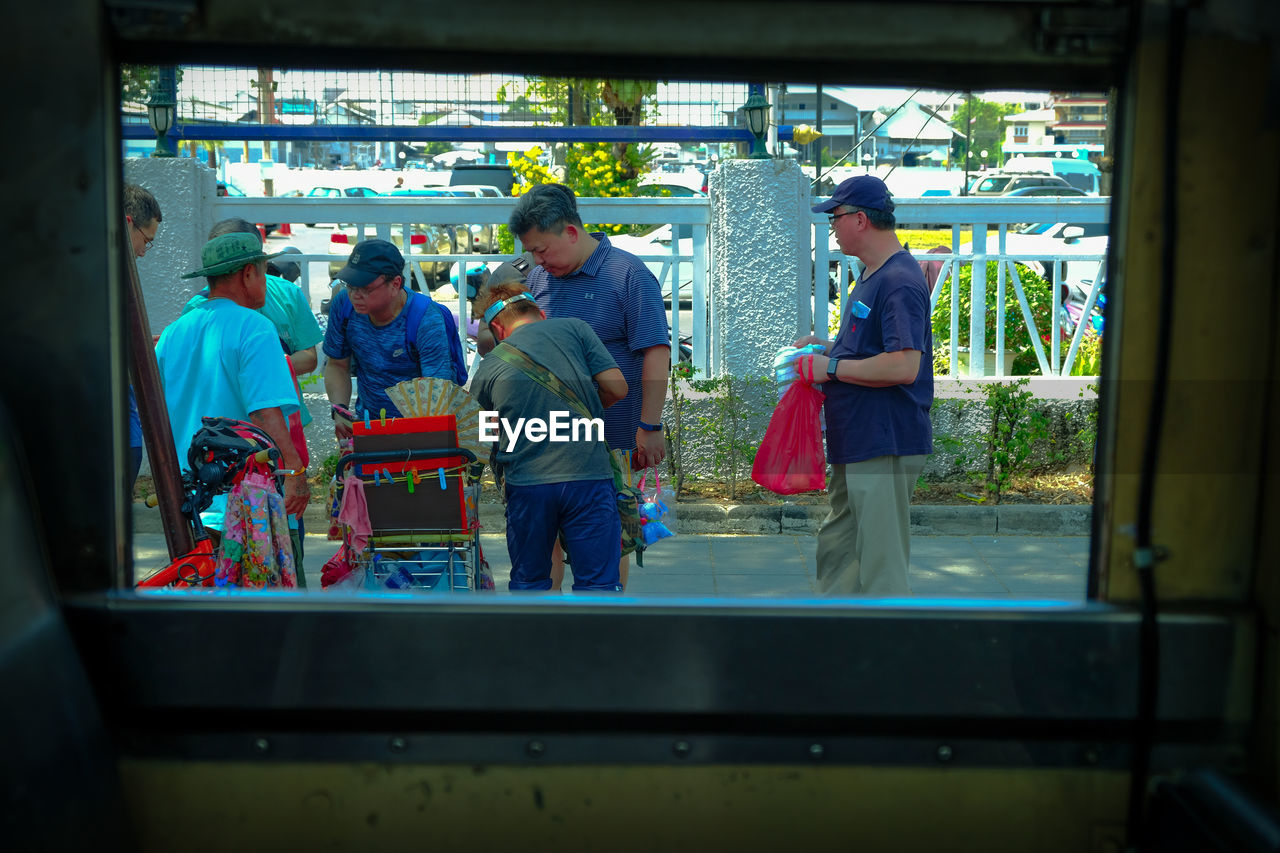 GROUP OF PEOPLE STANDING IN BUS