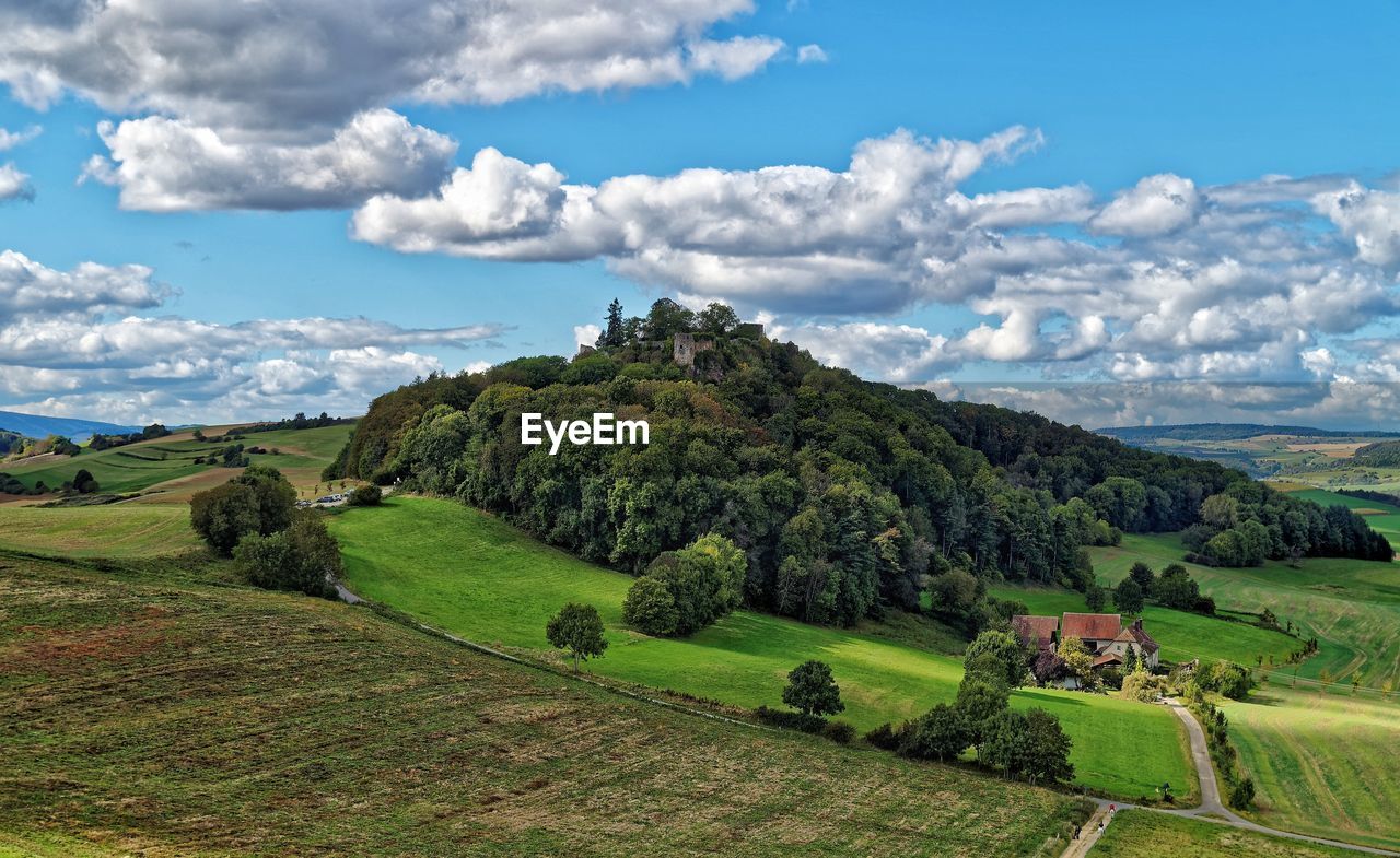 Scenic view of agricultural landscape against cloudy sky