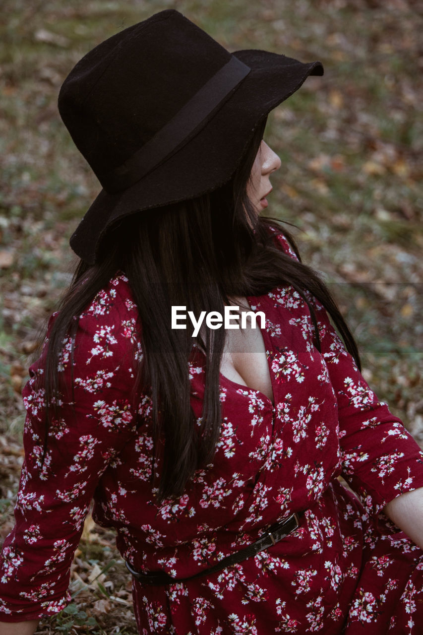 Woman wearing hat siting on field