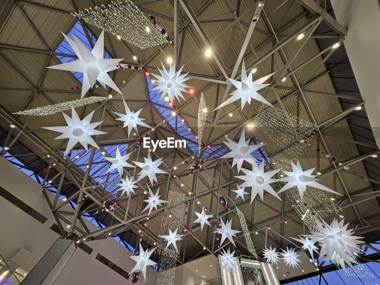 ceiling, decoration, low angle view, hanging, illuminated, indoors, star shape, shape, no people, lighting equipment, celebration, christmas, holiday, christmas decoration, pattern, built structure, lighting, architecture, night, christmas lights