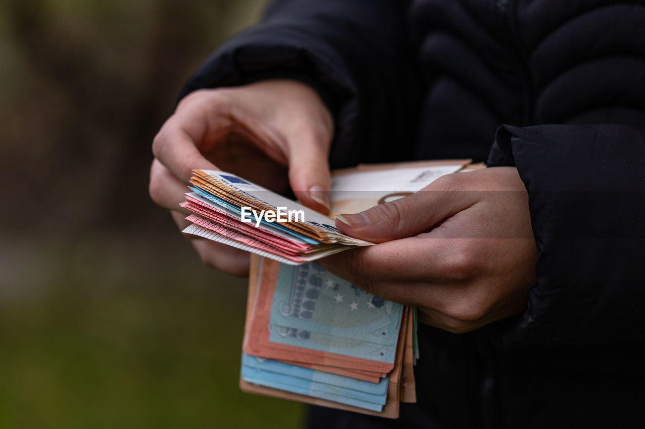 Midsection of man counting paper currency