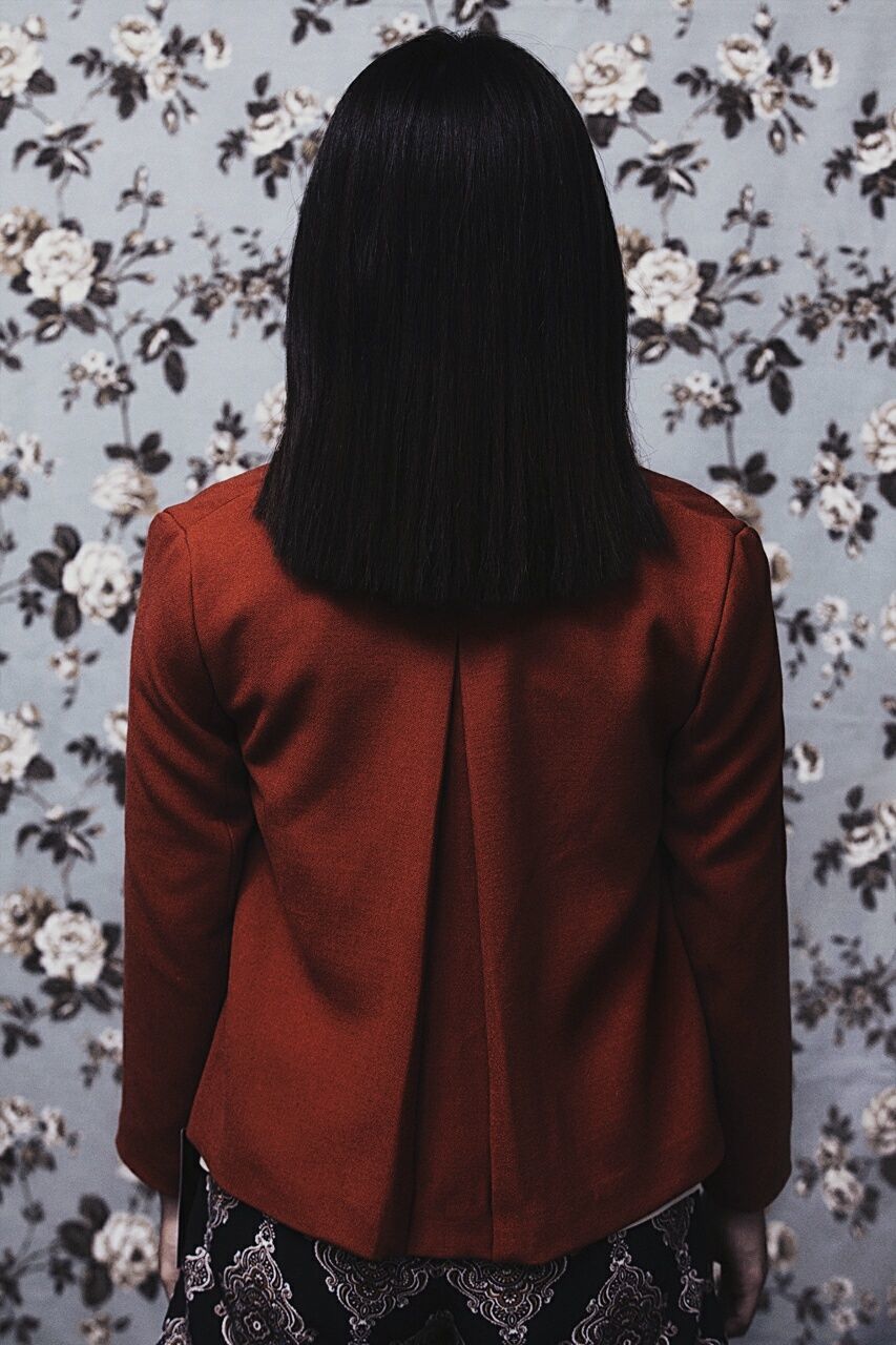 Rear view of woman with straight hair against wall at home