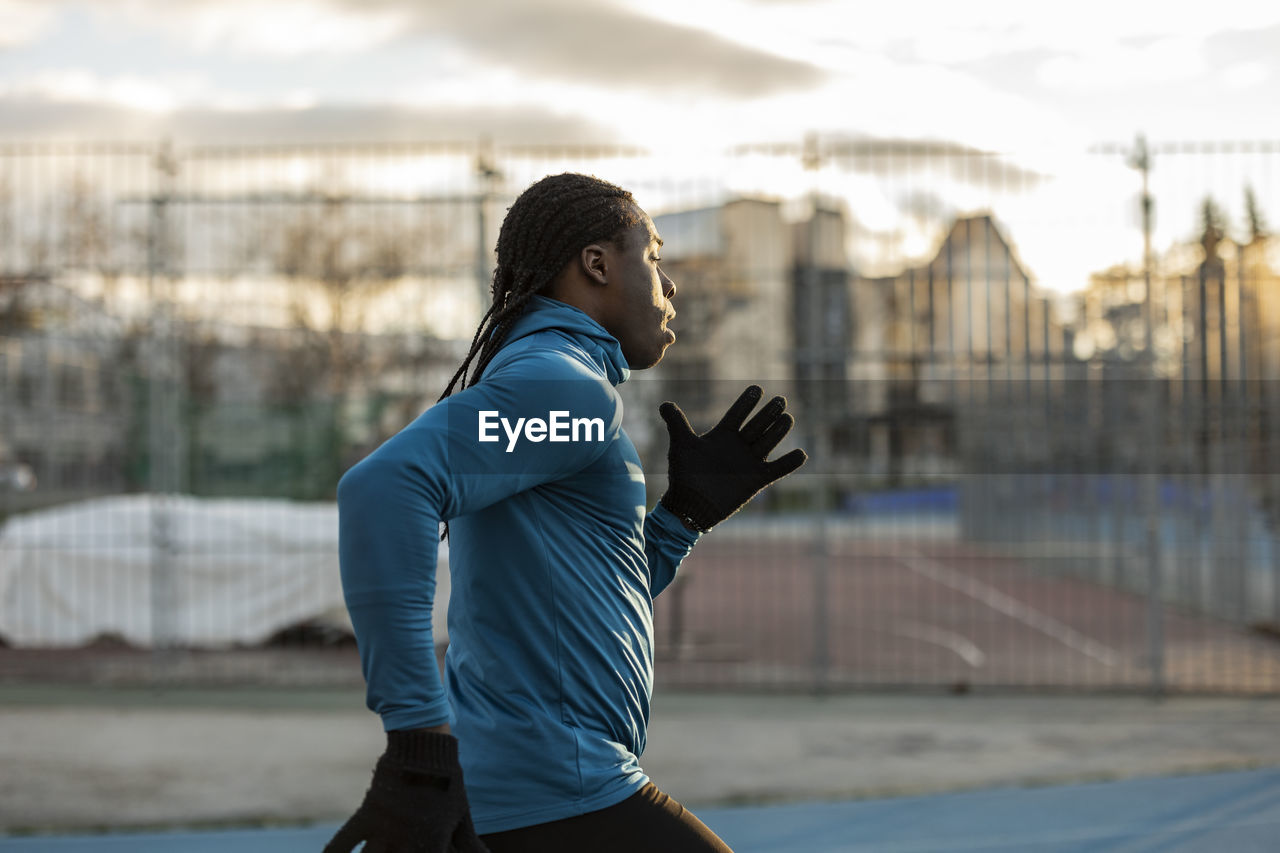 Young man running on sports track