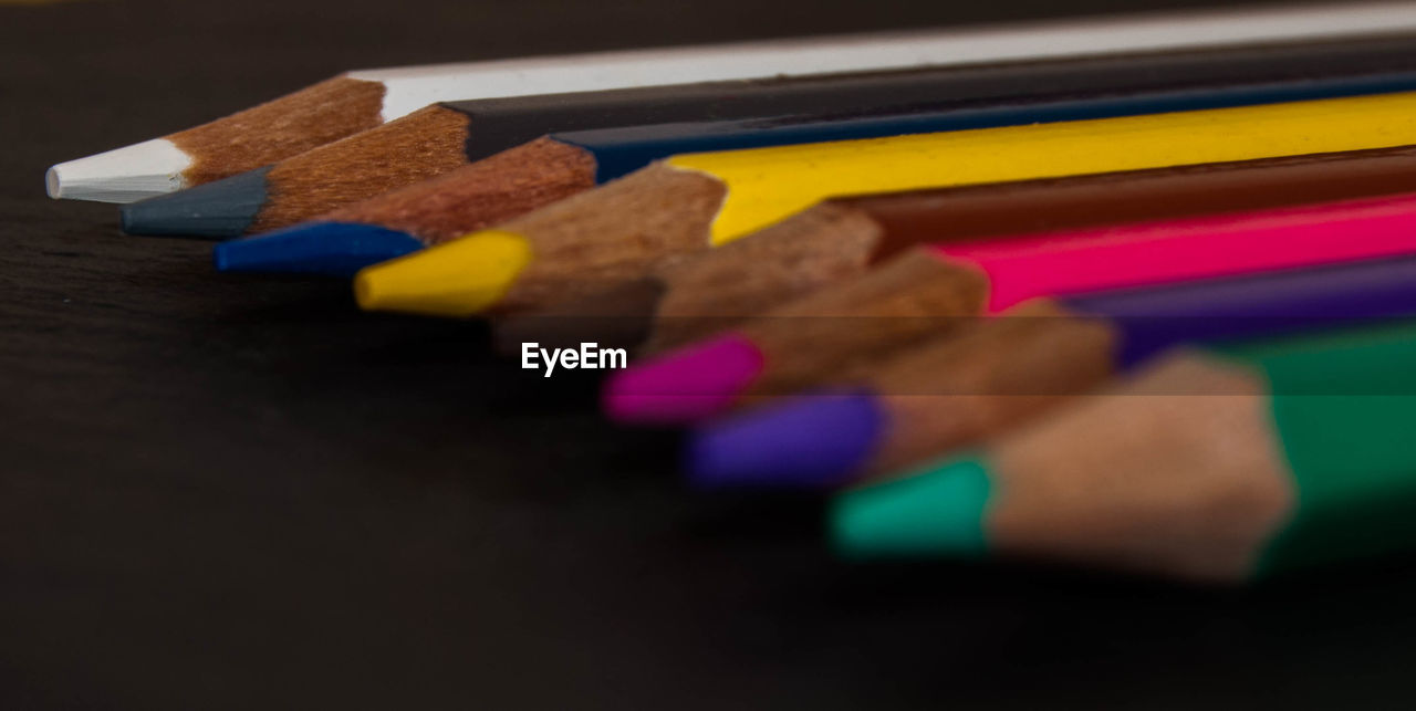 Close-up of multi colored pencils on table