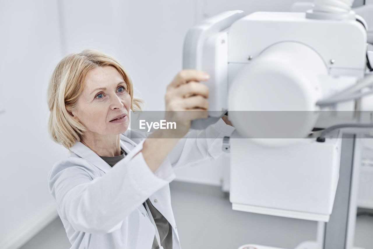 Doctor looking at x-ray machine in clinic