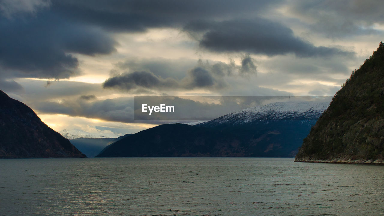 SCENIC VIEW OF SEA BY MOUNTAINS AGAINST SKY