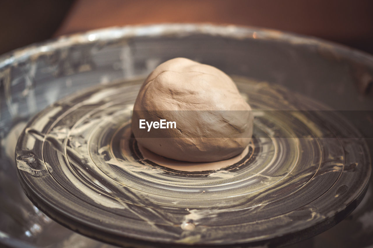 A piece of clay on a potter's wheel close-up in the pottery workshop