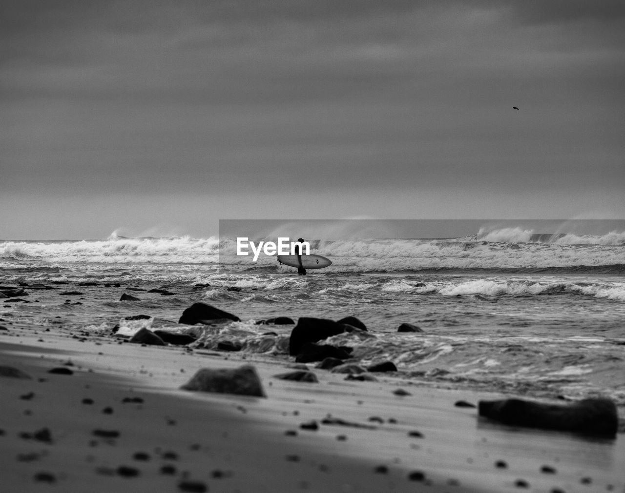 MAN ON BEACH AGAINST SKY