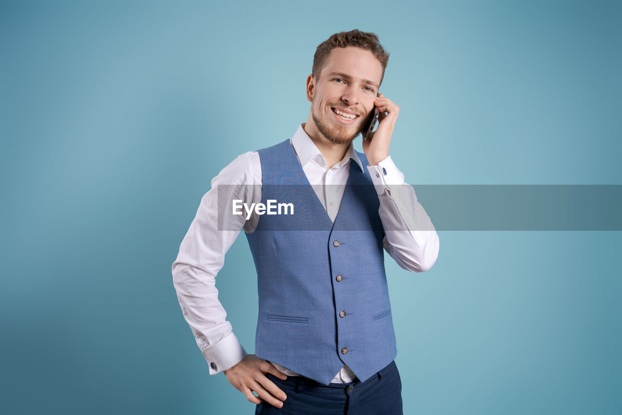 Great news. happy young man in shirt and vest gesturing and smiling while