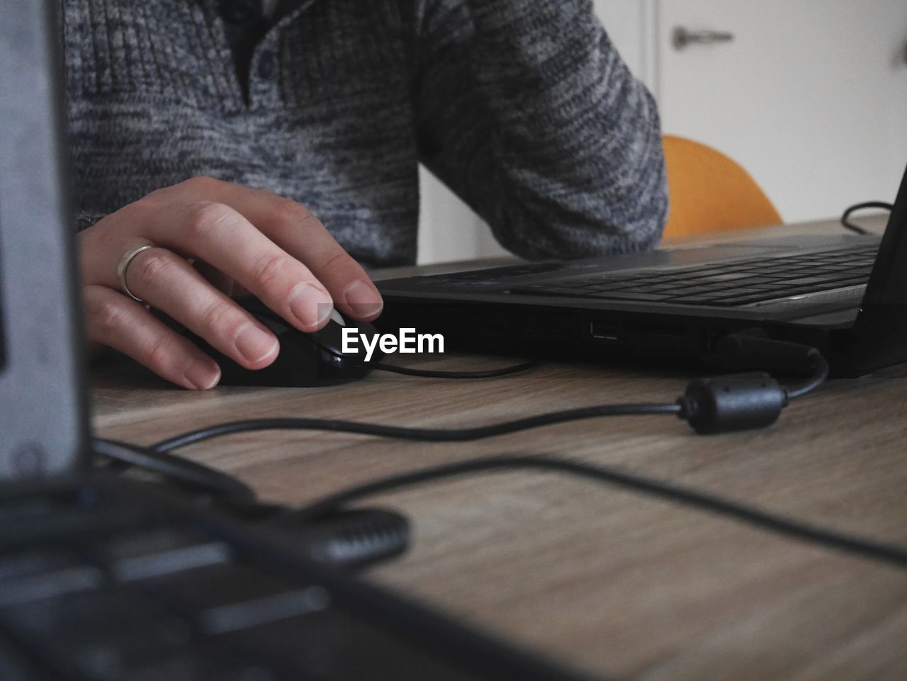 Midsection of man using laptop on table