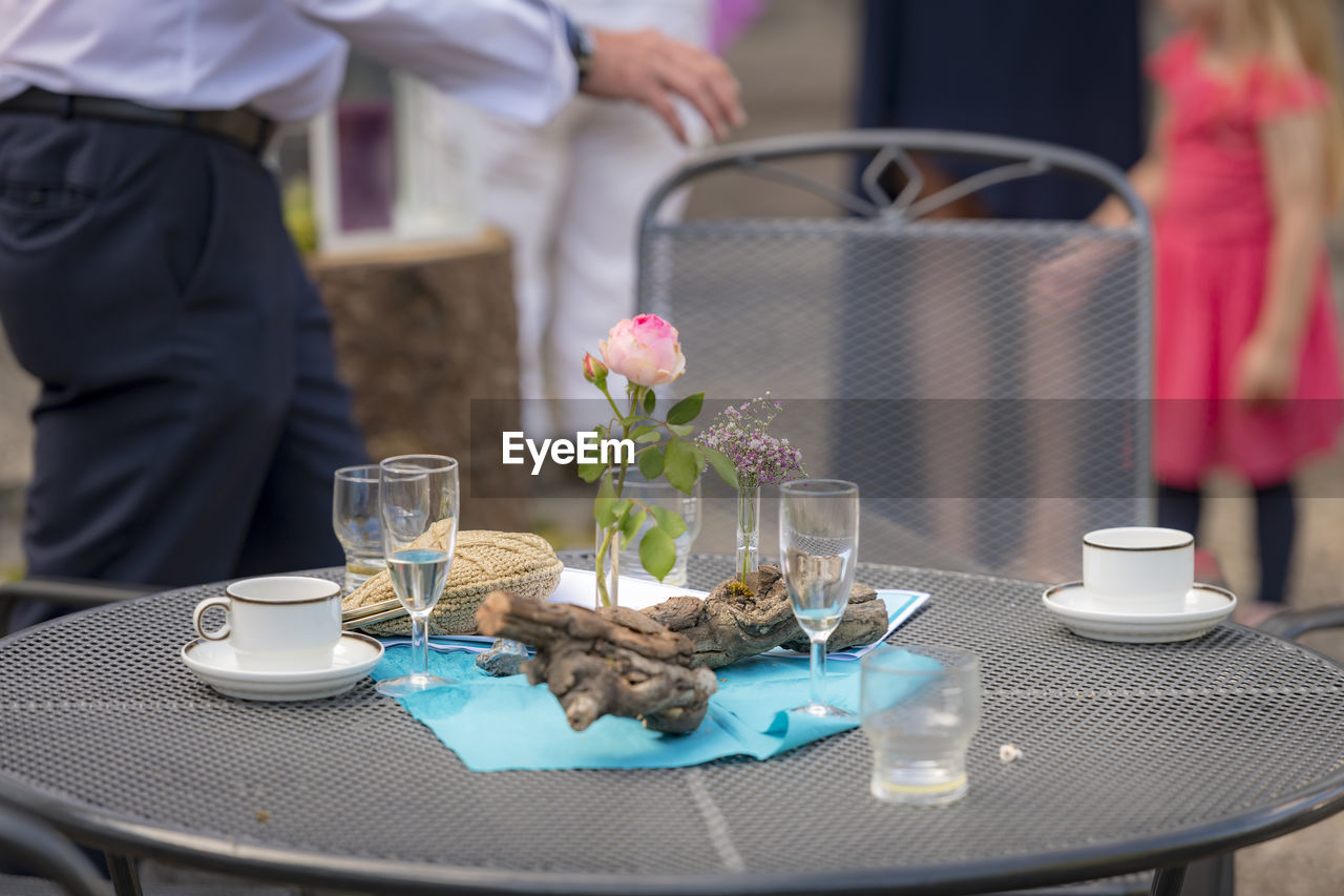 After the party - flowers decoration with used glasses and plates stands on a patio table