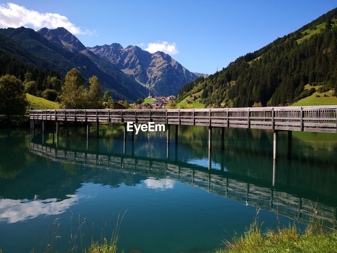 Scenic view of lake and mountains against blue sky