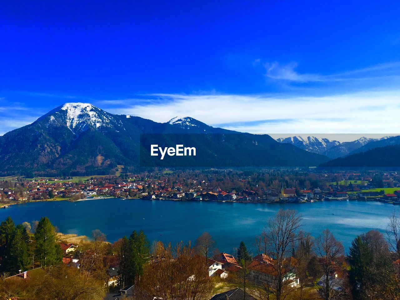 Scenic view of lake and mountains against blue sky