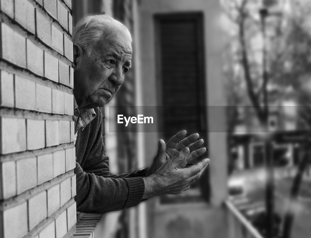 Thoughtful senior man looking through window