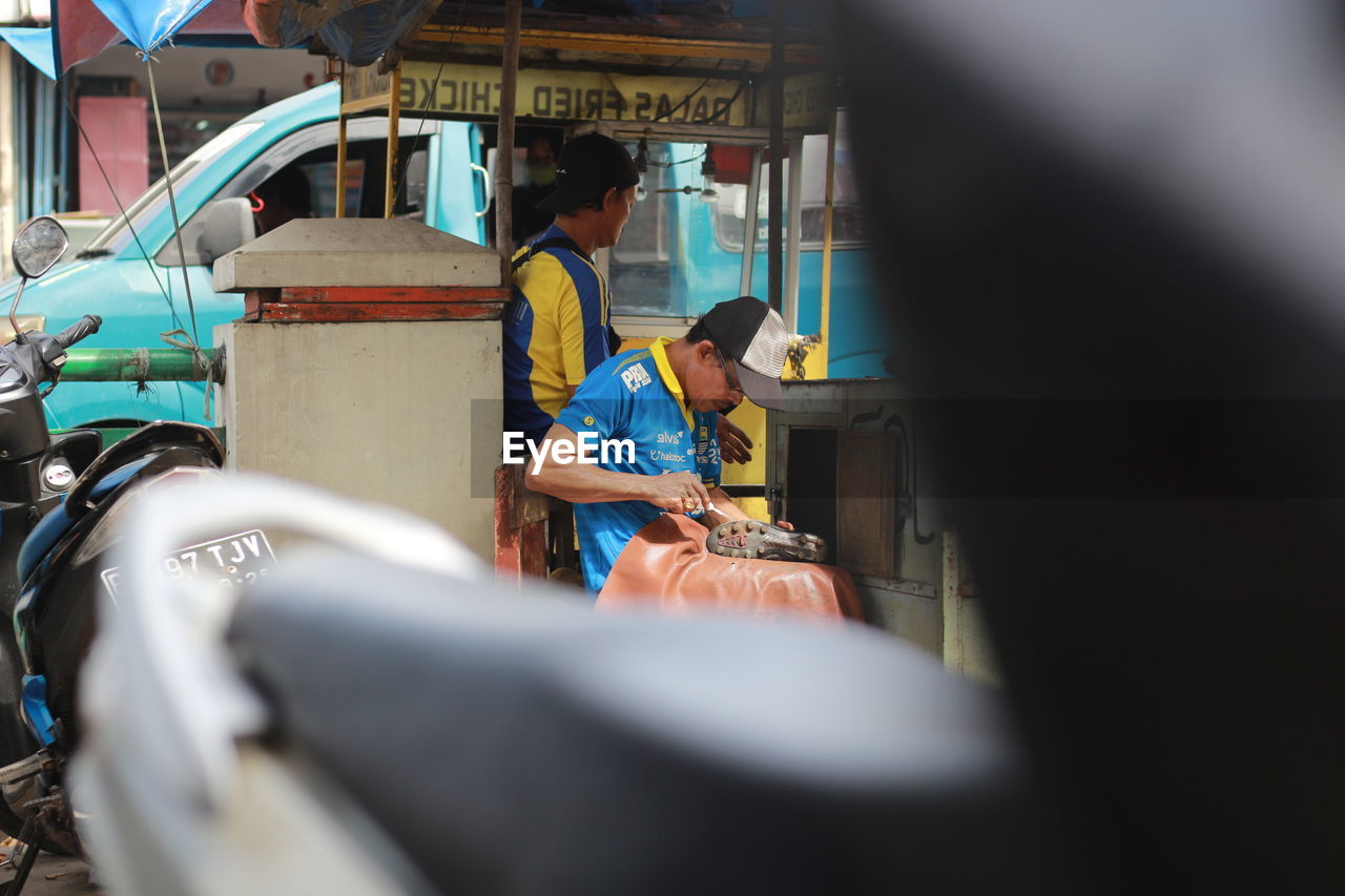 adult, transportation, men, focus on background, mode of transportation, occupation, vehicle, selective focus, two people, working, day, car, women, sitting, mature adult, land vehicle, person