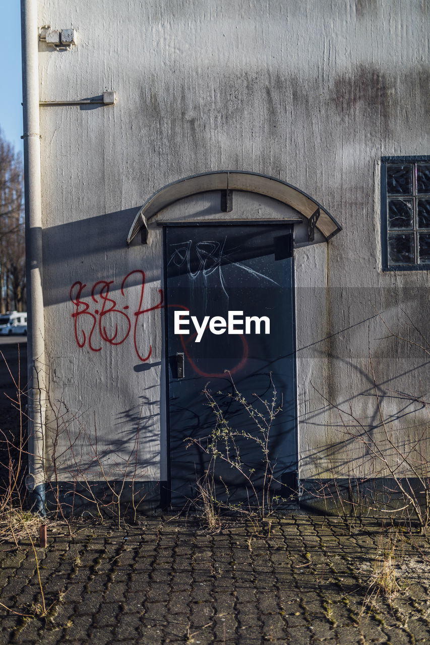 GRAFFITI ON WALL OF BUILDING WITH STREET