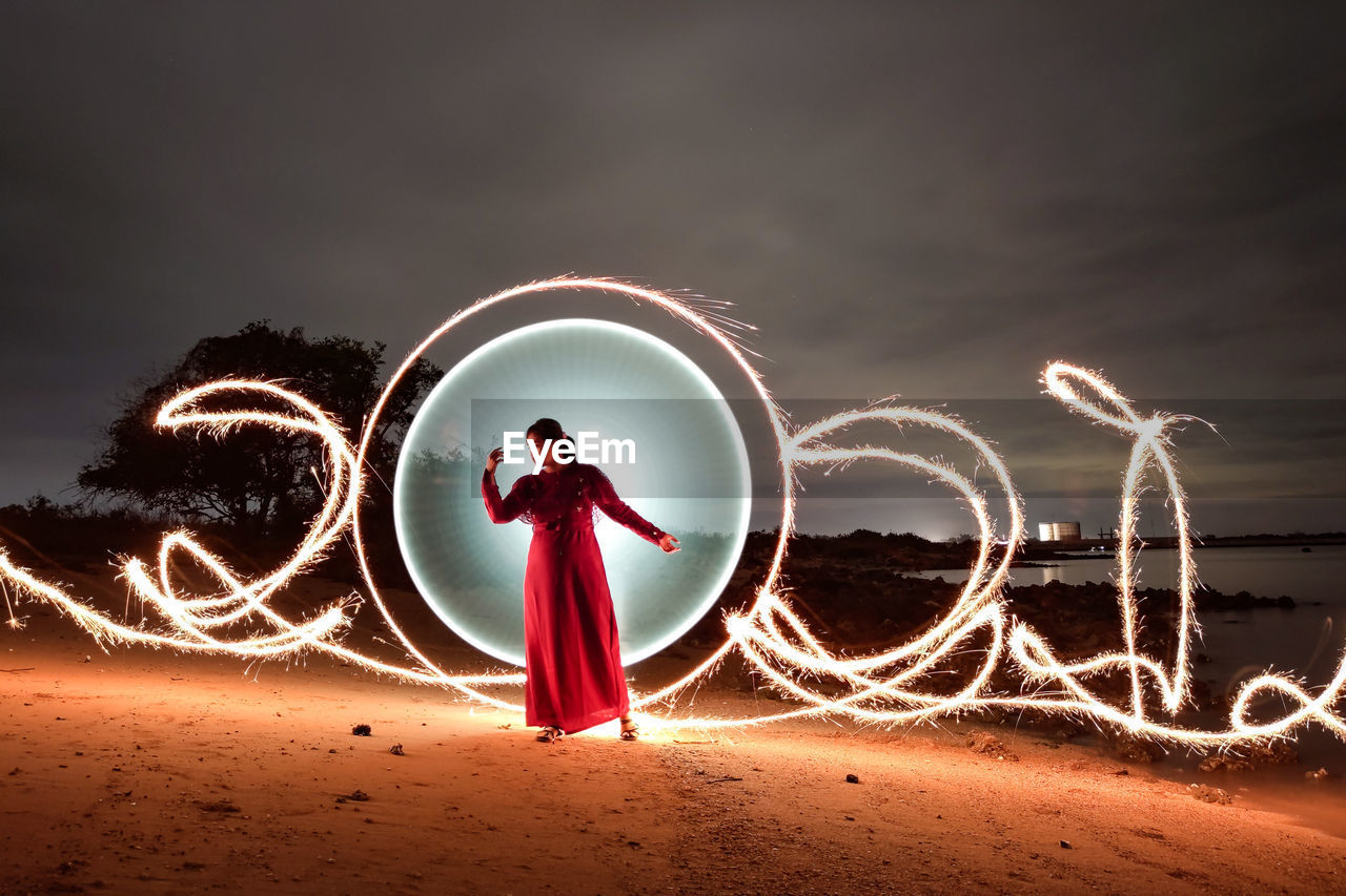 Light painting on beach against sky at night