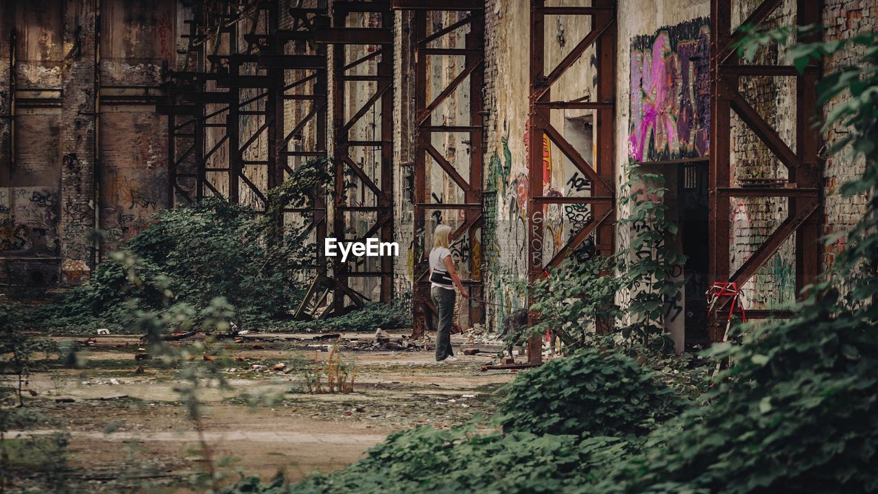 Woman standing by old warehouse