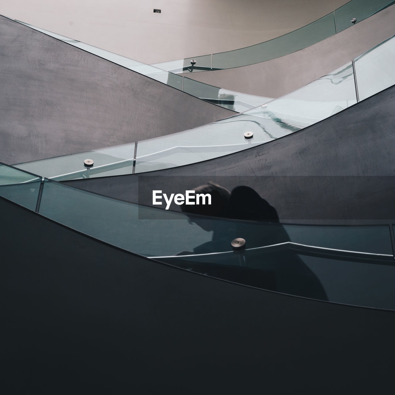 LOW SECTION OF WOMAN SITTING ON STEPS IN STAIRCASE