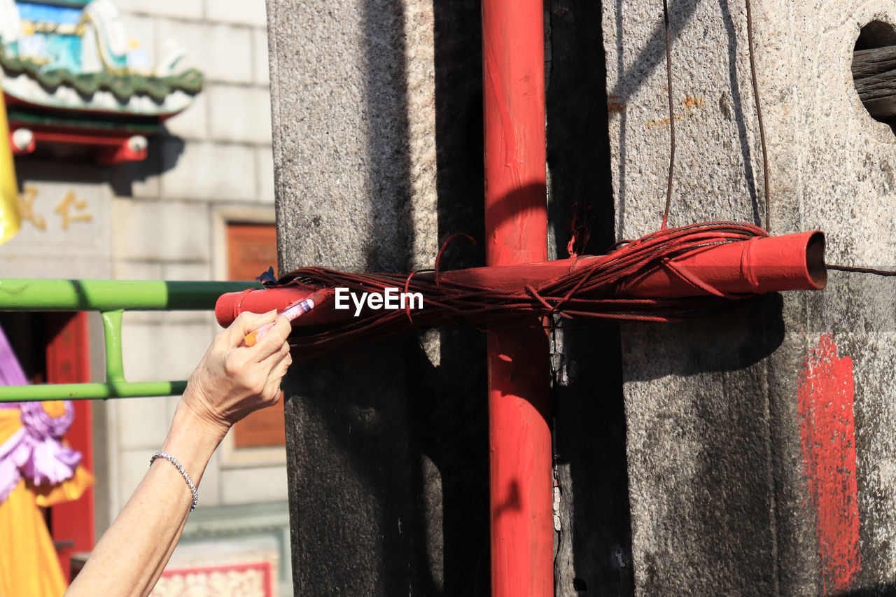 CLOSE-UP OF HAND HOLDING TIED UP OUTDOORS