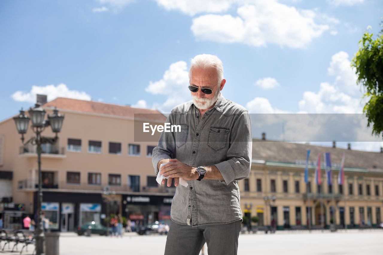 Man standing in city against sky