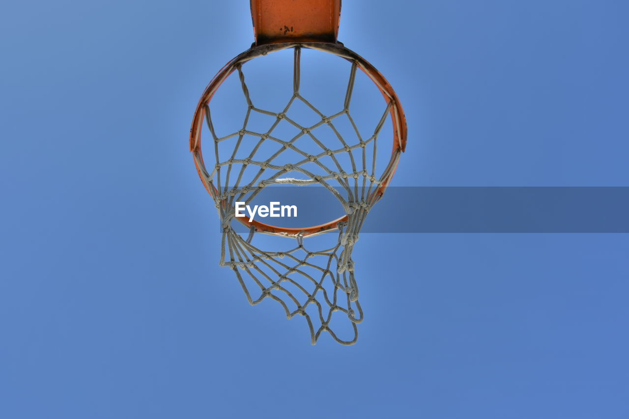 Low angle view of basketball hoop against clear blue sky