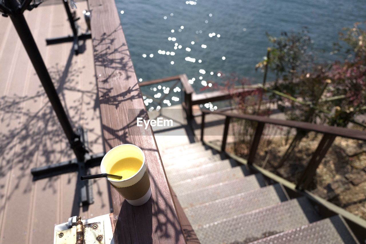 HIGH ANGLE VIEW OF STAIRCASE IN SEA BY RAILING