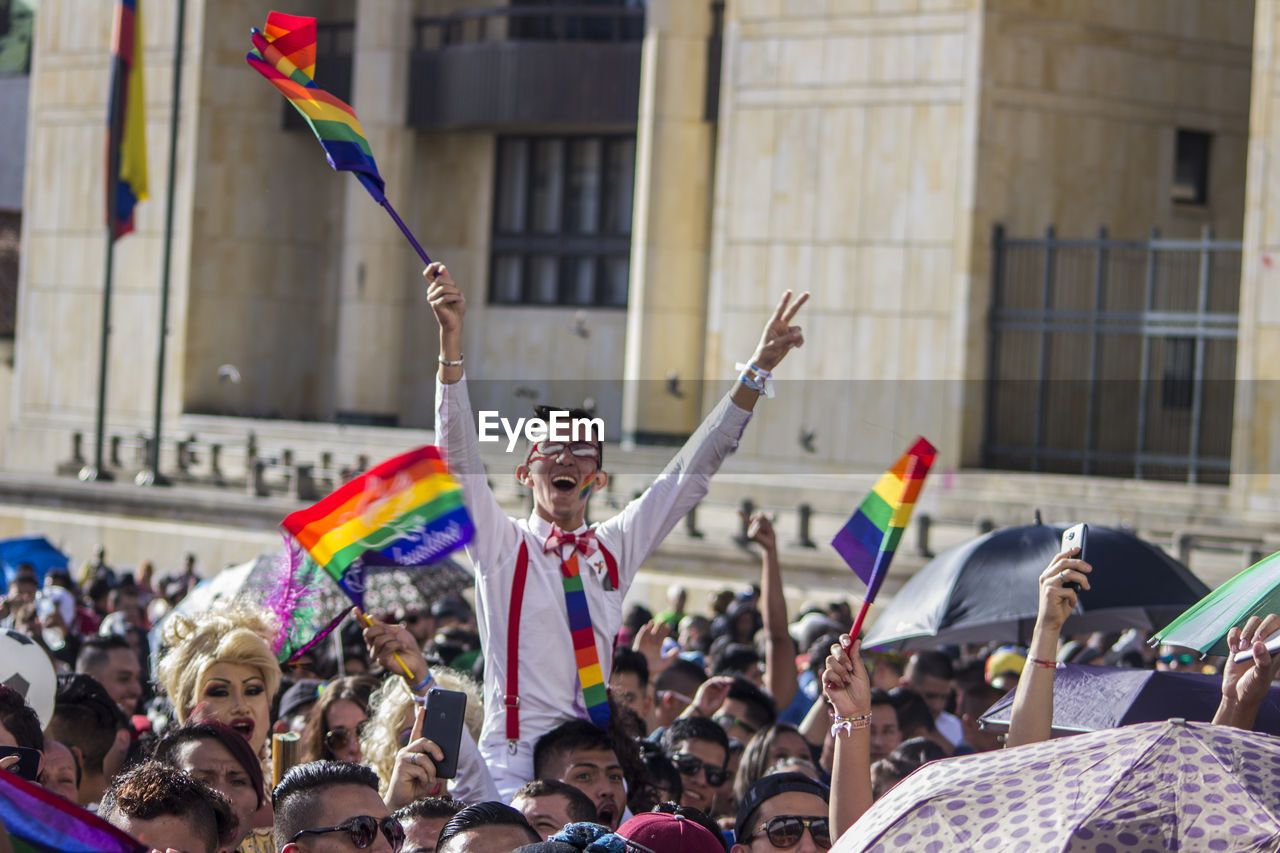 Crowd with rainbow flags in city