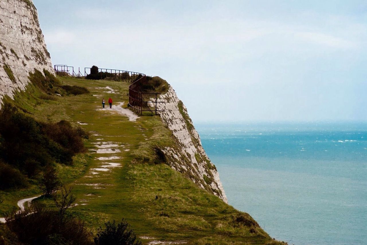 Scenic view of cliff and sea against sky