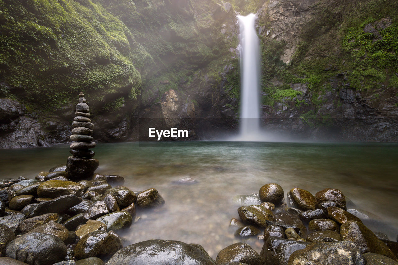 SCENIC VIEW OF WATERFALL AGAINST MOUNTAINS