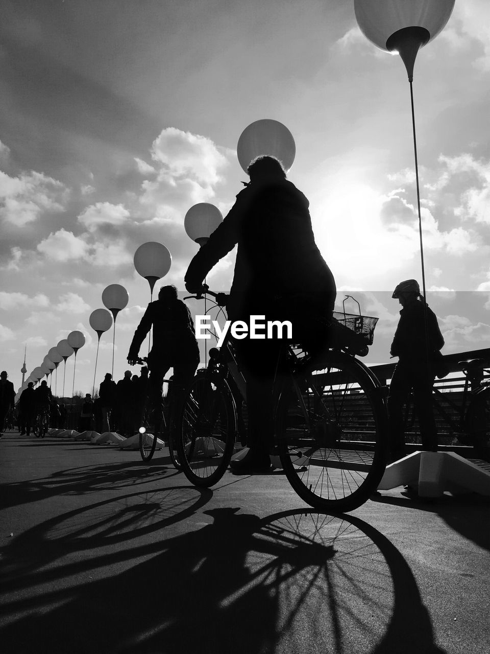 People riding bicycle by lighting equipment on road