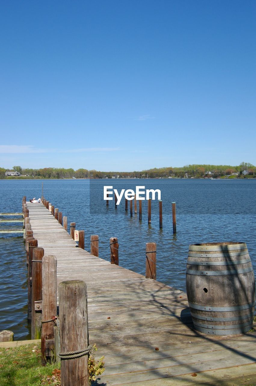 water, shore, sea, sky, wood, nature, coast, clear sky, pier, blue, scenics - nature, tranquility, day, bay, ocean, no people, tranquil scene, post, vacation, body of water, dock, beauty in nature, land, sunny, beach, sunlight, jetty, outdoors, wooden post, architecture, non-urban scene, travel destinations, transportation, landscape, travel, copy space, horizon, idyllic, nautical vessel, reflection, in a row, environment