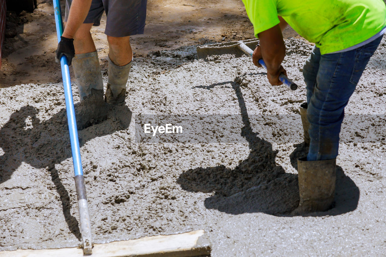 LOW SECTION OF MEN WORKING ON CONSTRUCTION SITE